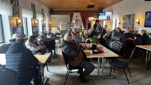 a group of people sitting at tables in a restaurant at Sjømannskirken Narvik in Narvik