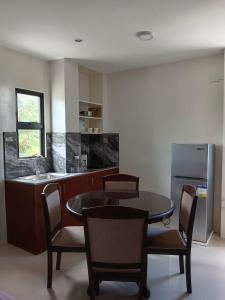 a kitchen with a table and chairs and a refrigerator at Residencia de Azucena in Tacloban
