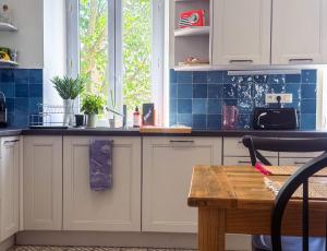a kitchen with white cabinets and blue tiles at Superbe appartement spacieux, calme, central in Toulon
