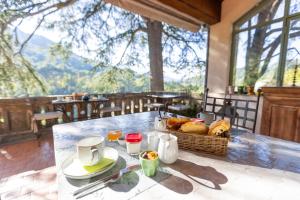 a table with a basket of bread and coffee on it at Le Mas Fraissinet - ACCES ESPACE DETENTE pour toutes les chambres sauf la suite COCON qui a son Jacuzzi privé in Saint-Jean-de-Valériscle