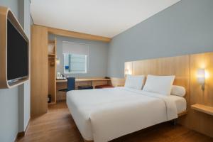 a hotel room with a bed and a tv at Ibis Jakarta Senen in Jakarta