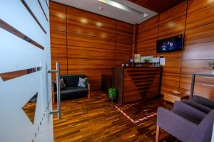 a living room with wood paneling and a couch and chair at Samali Residence in Eforie Nord