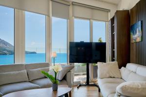 a living room with white furniture and large windows at Skyline resort CG in Budva