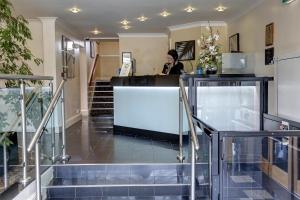 a woman standing at a counter in a lobby at Best Western Plus Milford Hotel in South Milford