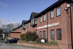 a brick building with a sign on the side of it at Best Western Plus Milford Hotel in South Milford