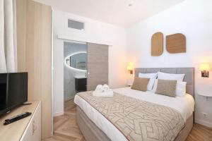 a bedroom with a bed and a flat screen tv at DELUXE SEAVIEW BALCONY - 2 min PALAIS & BEACH in Cannes