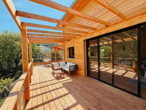 a wooden deck with a pergola at Le Chalet de la Boussonie in Les Vans +7 photos
