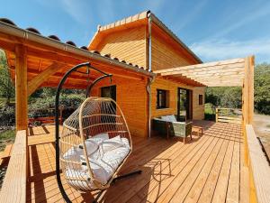 a wooden deck with a swing on a house at Le Chalet de la Boussonie in Les Vans