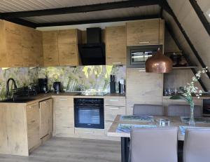 a kitchen with wooden cabinets and a table with chairs at Haus Rosengarten 2 in Bad Wünnenberg