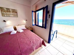 a bedroom with a bed and a view of the ocean at Blue Thea in Lentas