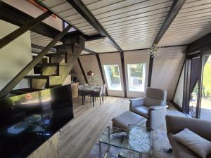 a living room with a large television and a living room with a table at Haus Rosengarten 2 in Bad Wünnenberg +15 photos