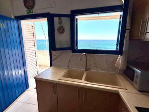 a kitchen with a sink and a view of the ocean at Blue Thea in Lentas +37 photos