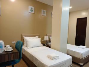 a hotel room with two beds and a mirror at BEAVER HOTEL and RESIDENCES in Cebu City +7 photos