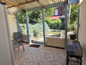 a screened in porch with a view of a garden at MAISON LA SOURCE d'hôte à Roubaix in Roubaix
