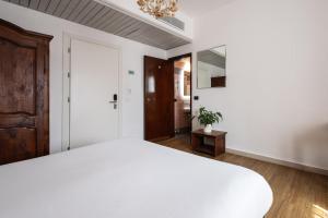 a bedroom with a large white bed and a closet at Hotel Verdi Pisa in Pisa +41 photos