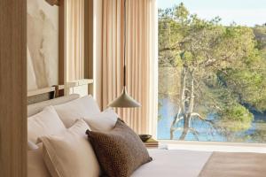 a bedroom with a bed with a large window at Ikos Porto Petro in Portopetro