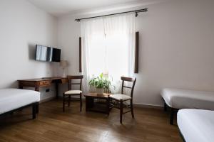 a bedroom with a desk and a bed and a desk with chairs at Hotel Verdi Pisa in Pisa