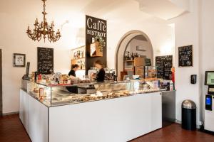 a counter in a bakery with two people behind it at Hotel Verdi Pisa in Pisa