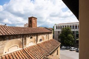 an old building with a clock tower in a city at Hotel Verdi Pisa in Pisa