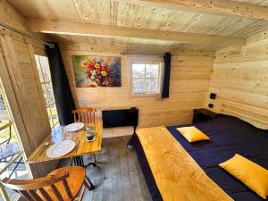 a room with a bed and a table in a cabin at ARDENNE CAMPING MABOGE in La-Roche-en-Ardenne