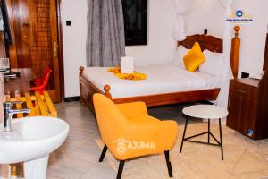 a bedroom with a bed and a sink and a chair at The Grand Brystal Hotel in Busia +23 photos