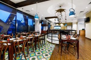 a restaurant with wooden tables and chairs and a bar at StarRay Hotel Jakarta Kebayoran in Jakarta