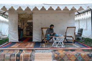 a man sitting at a table in a tent at Camp The Sanga Manali in Tāndi
