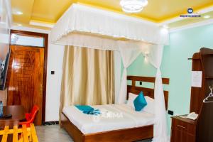 a bedroom with a bed with a canopy at The Grand Brystal Hotel in Busia