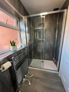 a bathroom with a shower with a glass door at Stylish Central Kettering Apartment by SJP in Kettering +18 photos