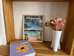 a book and a vase with flowers and a picture at Superbe appartement spacieux, calme, central in Toulon