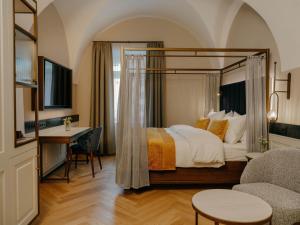 a hotel room with a bed and a desk and a chair at IMLAUER Palais Mirabell in Salzburg