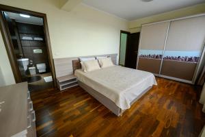 a bedroom with a large bed and wooden floors at Samali Residence in Eforie Nord