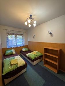 a bedroom with two beds and a dresser in it at Domek nad jeziorem Mierzyńskim 50m2 in Mierzyn