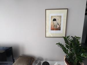 a picture hanging on a white wall with a plant at Seasons in Warmenhuizen