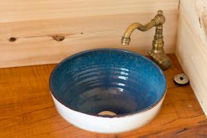 a sink with a faucet on a wooden floor at Magnifique kiosque verdoyant in Semur-en-Auxois