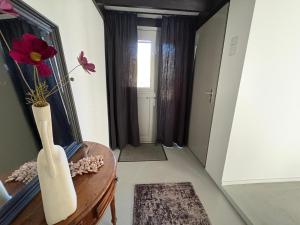 a hallway with a table and a mirror and a vase at Seasons in Warmenhuizen