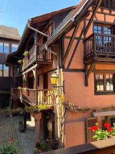 a building with balconies on the side of it at Hôtel de l'Ange in Niedermorschwihr