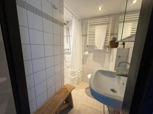 a white bathroom with a sink and a tub at Seasons in Warmenhuizen