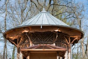 a wooden gazebo with a tin roof at Magnifique kiosque verdoyant in Semur-en-Auxois