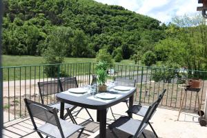 a table and chairs sitting on a patio with a fence at Maison Garde Barriere in Canilhac