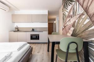 a room with a bed and a table and chairs at Stay COOPER l Tivoli in Bolzano +57 photos