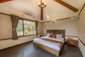 a bedroom with a large bed and a window at Palmwoods Retreat in Pune