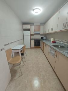 an empty kitchen with a table and chairs in it at Altet San Francisco in El Alted +5 photos