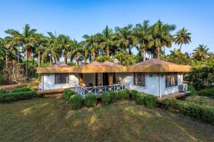 a large house with palm trees in the background at Palmwoods Retreat in Pune