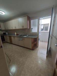 a kitchen with white cabinets and a tile floor at Altet San Francisco in El Alted