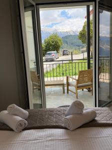 a bedroom with a bed and a balcony with a view at Panorama House in Pramanta