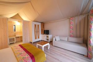 a bedroom with a bed and a couch in a room at Sakli Gol Evleri in Karacaören +35 photos