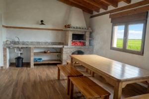 a living room with a wooden table and a fireplace at El Carloto Lanchares in Lanchares