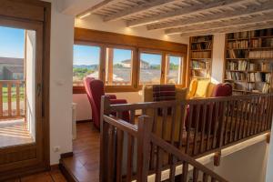 a room with a library with chairs and a balcony at El Carloto Lanchares in Lanchares