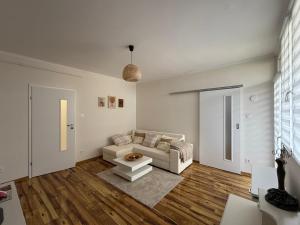 a living room with a couch and a table at Harmony Suite Apartment in Pápa